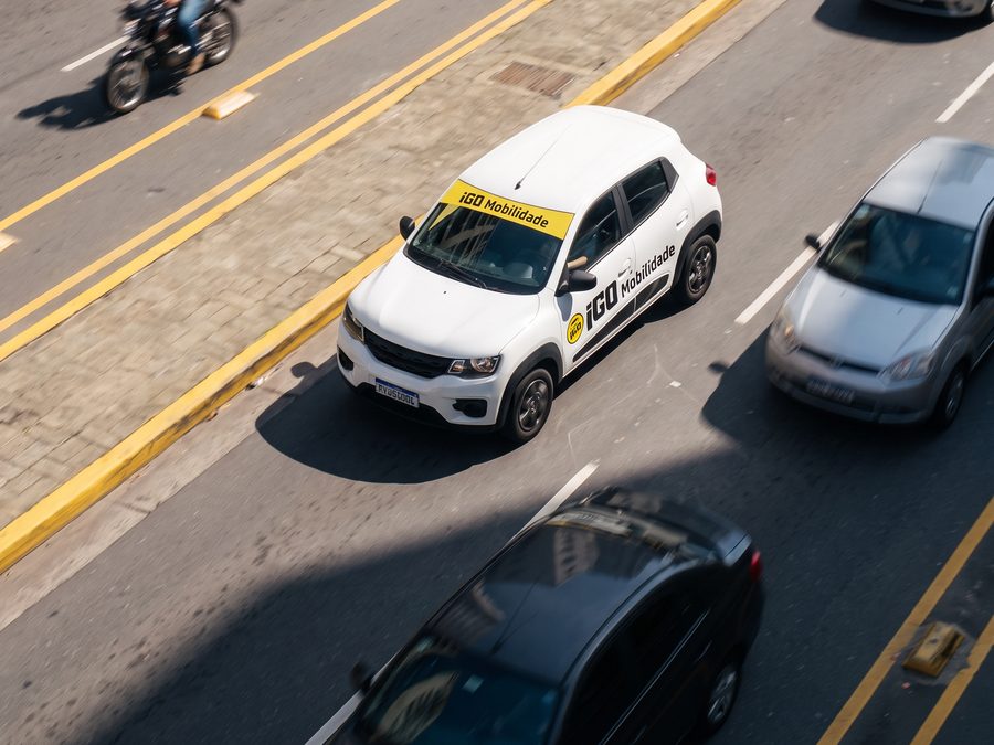Carro da frota iGO Mobilidade no trânsito de uma avenida movimentada de Marília